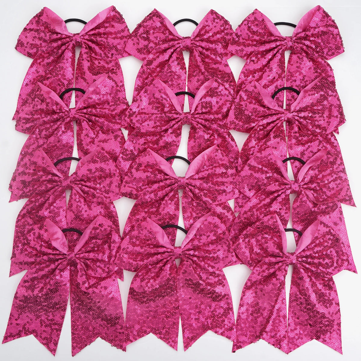 A pack of twelve glitter sequin pink pigtail bows for girls with elastic hair ties.