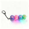 A keychain fidget toy shaped like a paw print in purple, pink, and blue, illuminated by an LED light.