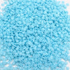 A pile of small, light blue polymer clay slices for DIY crafts.