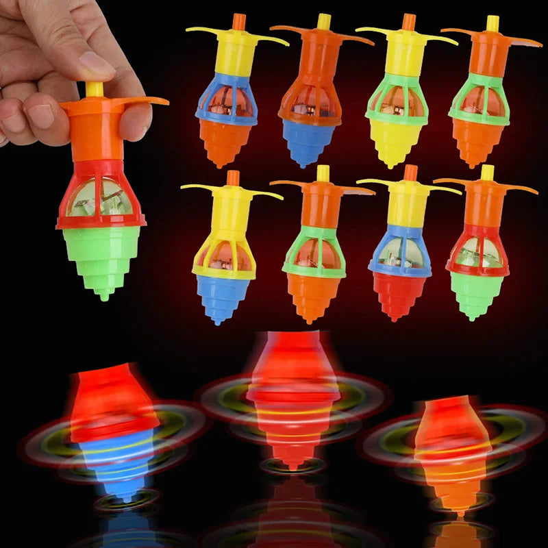 A hand holds multiple glow-in-the-dark spinning tops in various colors and shapes.
