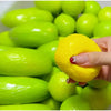 A hand is squeezing a bright yellow, color-changing lemon stress ball with a crunchy squishy texture.