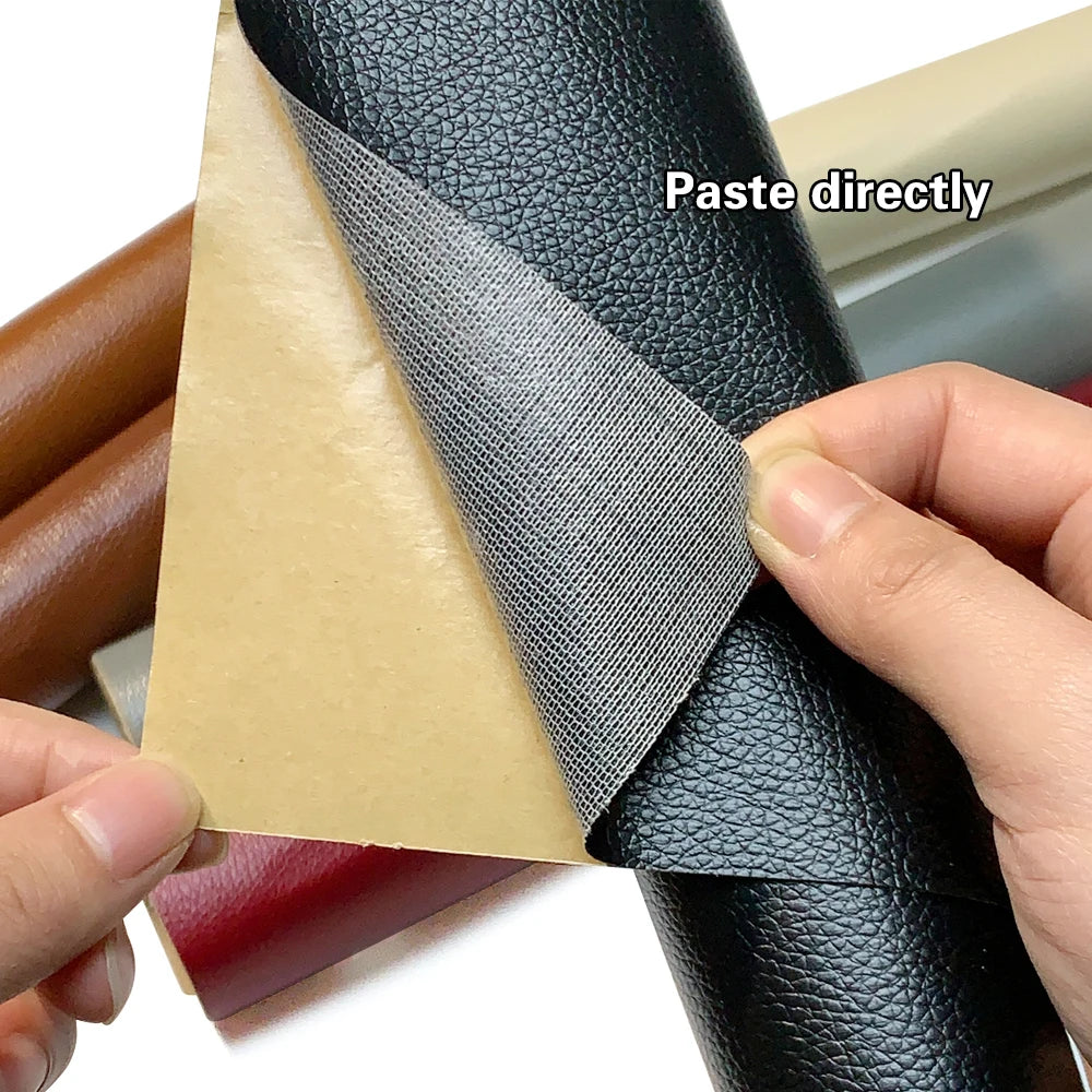 Close-up of a black PU leather material with a gray self-adhesive repair patch being applied to it.