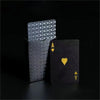 A black playing card with an Ace of Spades and a frosted gift box of poker cards.