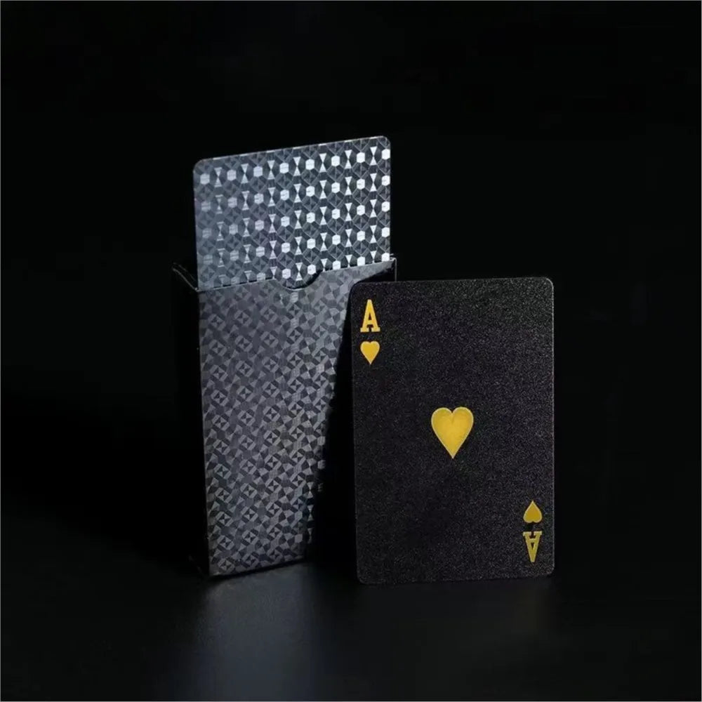 A black playing card with an Ace of Spades and a frosted gift box of poker cards.