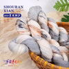 A bundle of hand-dyed Australian wool yarn showing a gradient of gray, white, and subtle brown tones, coiled in a wooden bask
