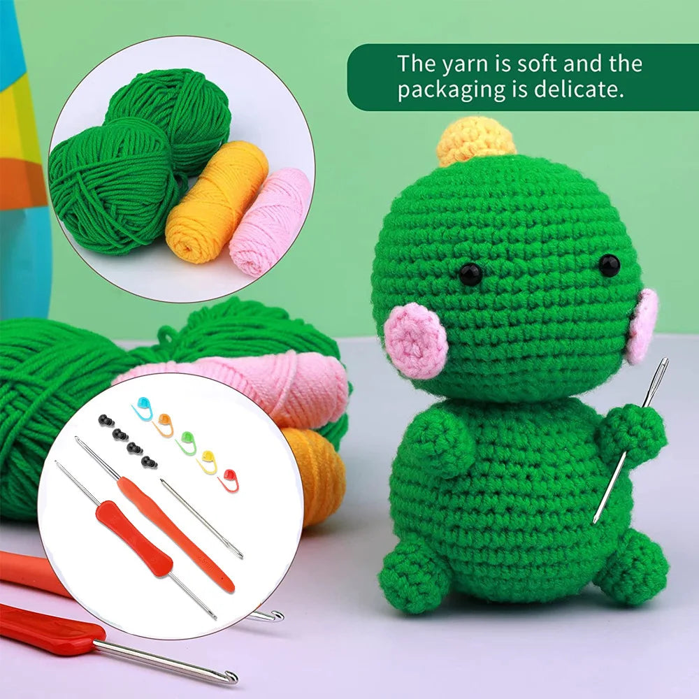 A handmade green crochet dinosaur toy with pink accents, surrounded by yarn and tools.