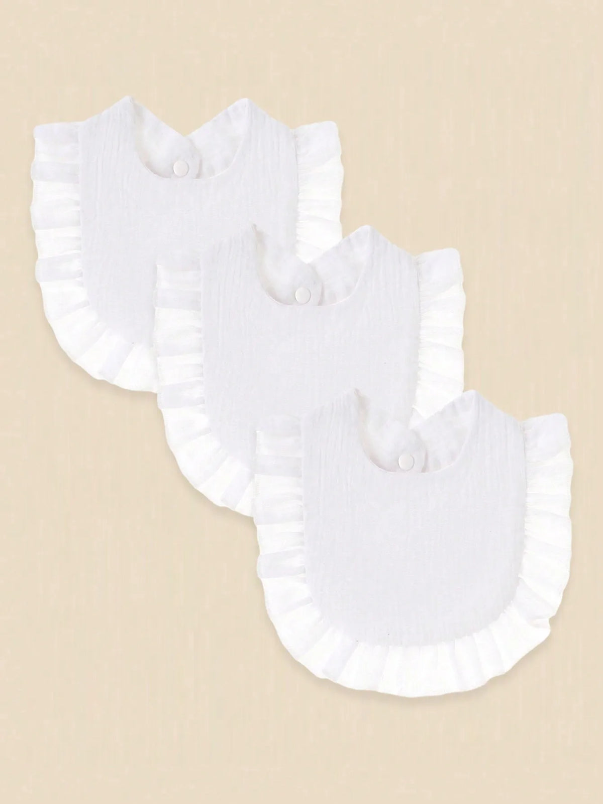 A pack of three white pure cotton muslin baby bibs with absorbent design