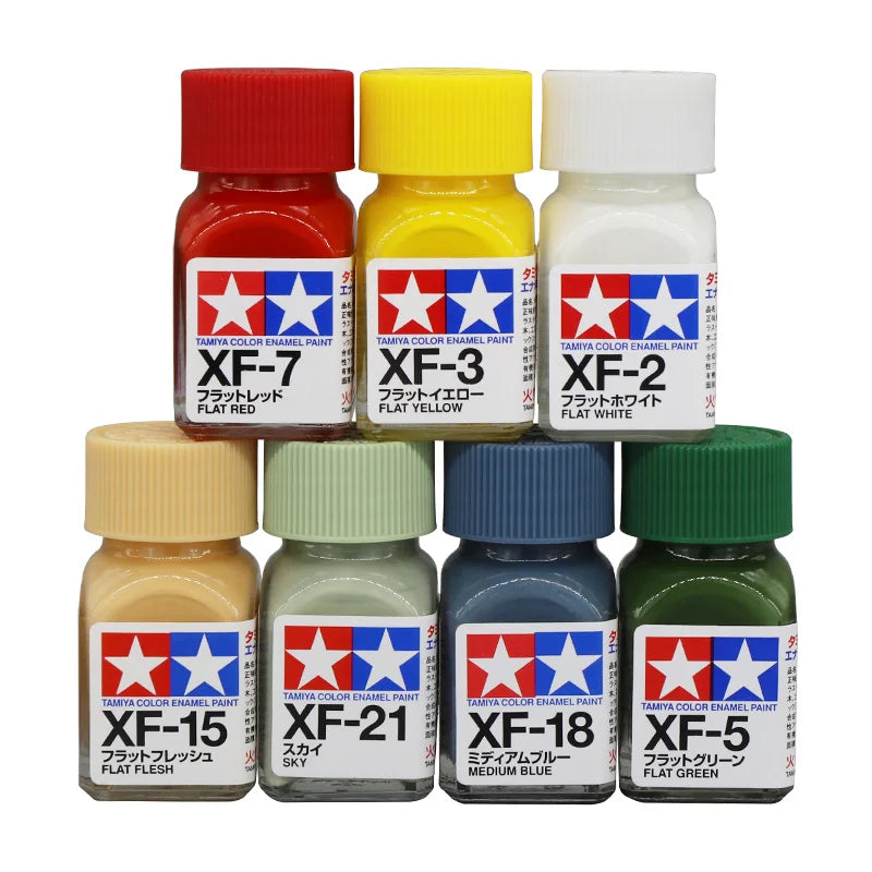 A collection of Tamya color enamel paints in various colors including red, yellow, white, and green.