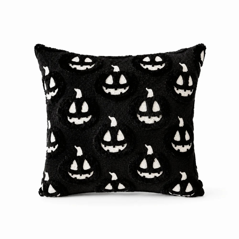 A black pillow cover featuring a repeating pattern of white ghost faces for Halloween decoration.