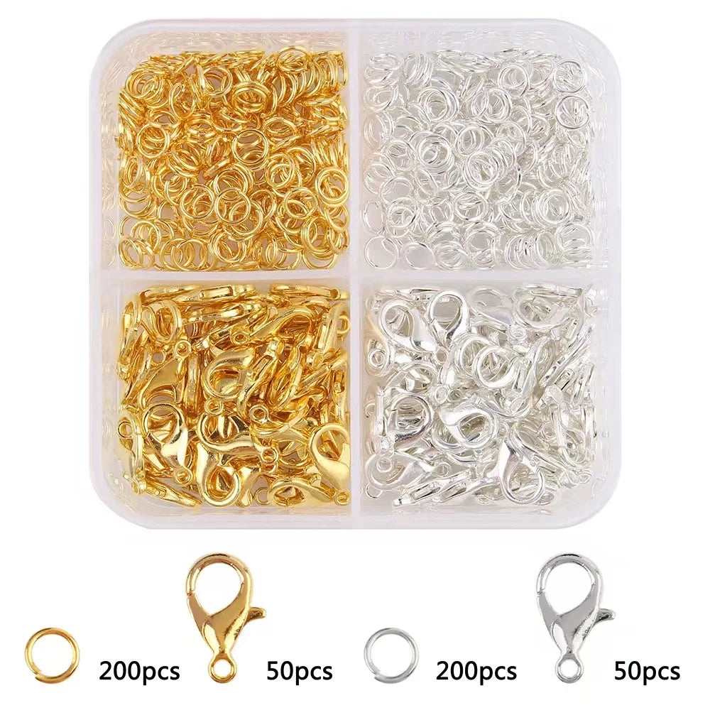 A clear plastic container holds various gold and silver lobster clasps and open jump rings for jewelry making.