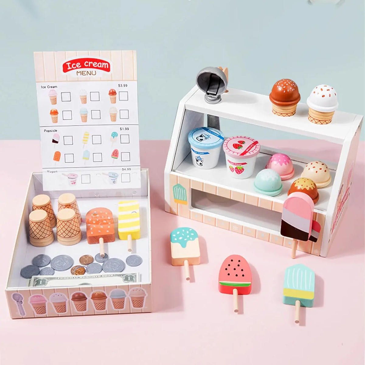 A wooden ice cream counter play set with various ice cream flavors and cups displayed on a white shelf.
