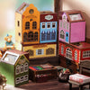 A collection of wooden miniature dollhouses and houses in various colors and styles displayed on a wooden surface.