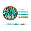 A collection of silicone round beads in white, cyan, turquoise, and matcha green colors displayed in a wooden bowl.
