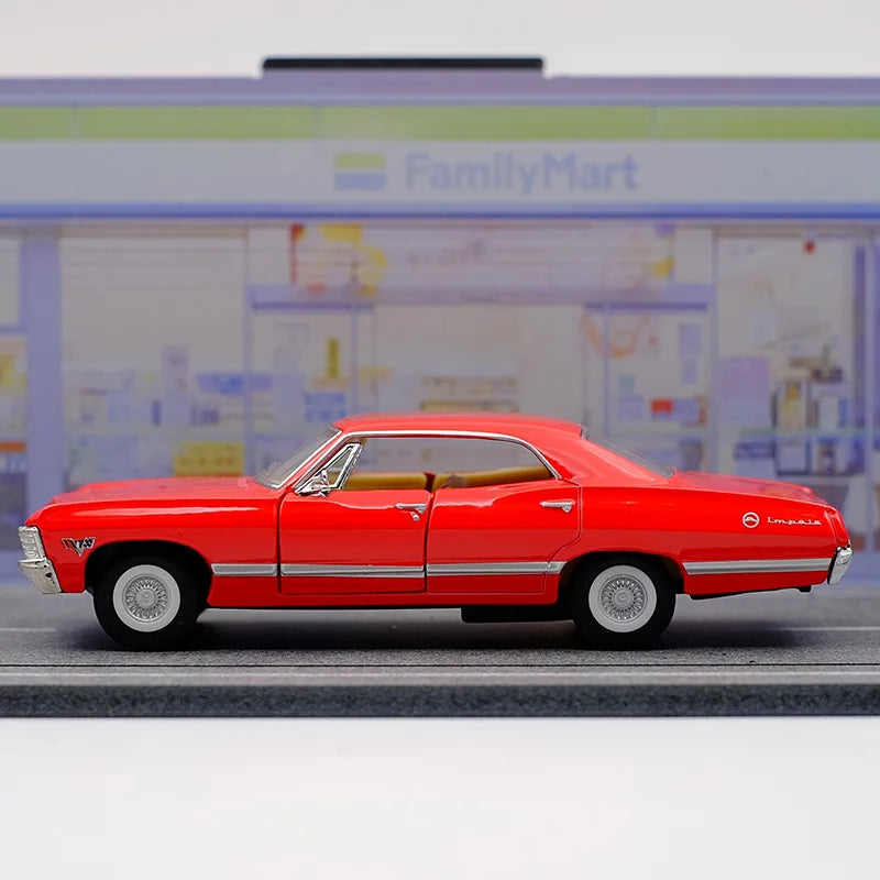 A red 1967 Chevrolet Impala diecast model car in a pull-back action pose on a gray surface.