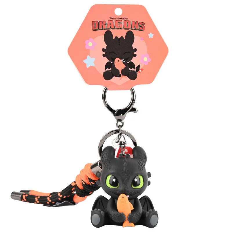 A black dragon keychain featuring a detailed figurine with orange accents and glowing green eyes.