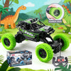 A black and green off-road climbing RC car with rubber tires and a remote control transmitter displayed on a green outdoor ba