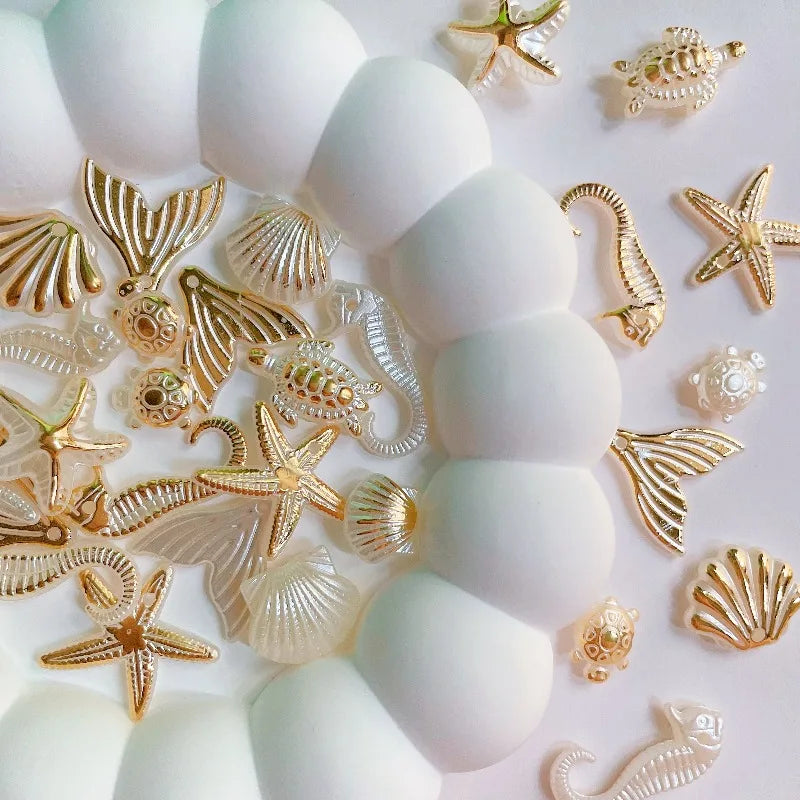 A collection of gold and clear acrylic ocean animal beads including starfish, shells, and sea creatures.
