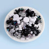A mix of black, white, and iridescent acrylic beads for DIY jewelry making.