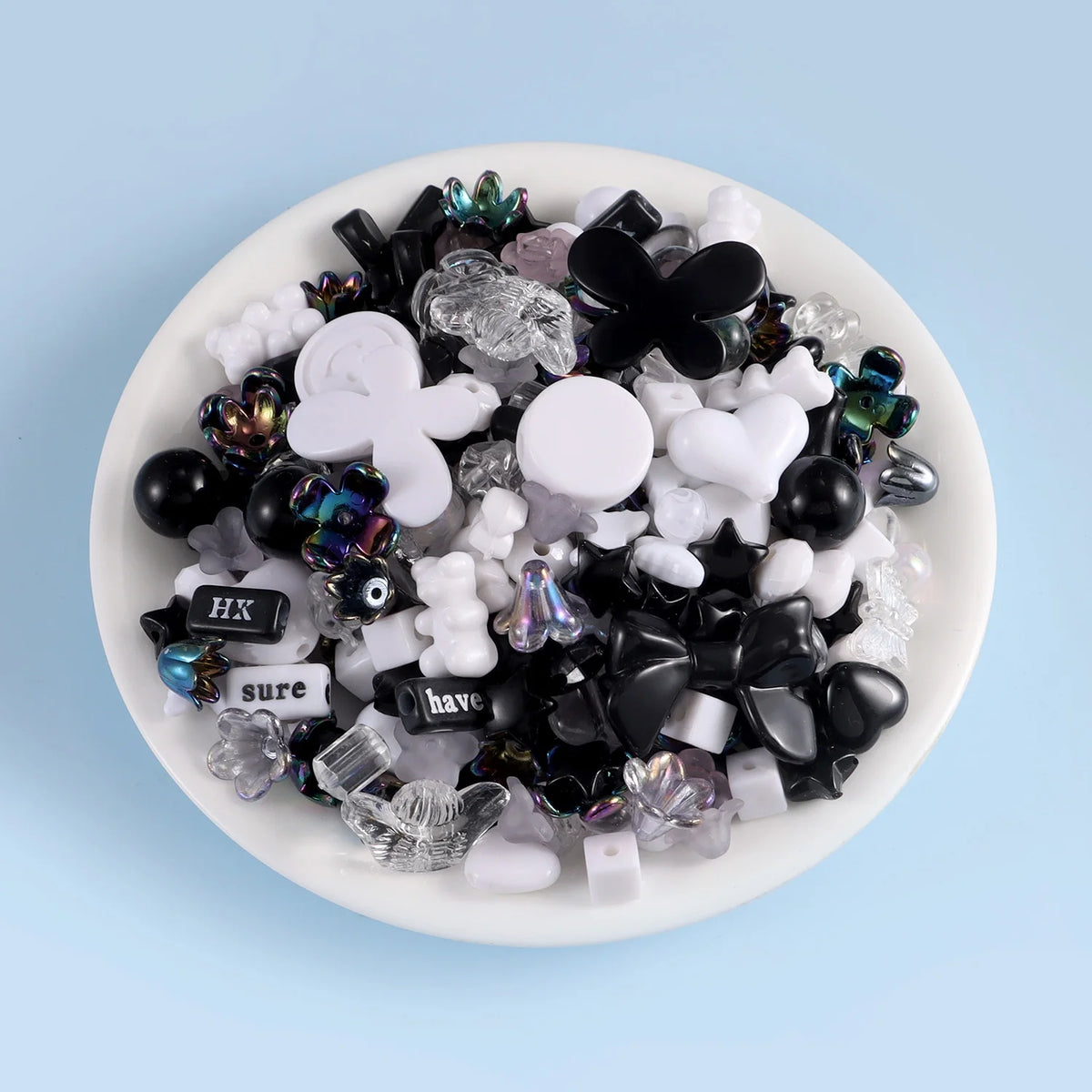 A mix of black, white, and iridescent acrylic beads for DIY jewelry making.