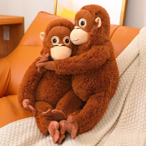 Zwei große, braune Plüschgorillas sitzen zusammen auf einer beigen Decke.