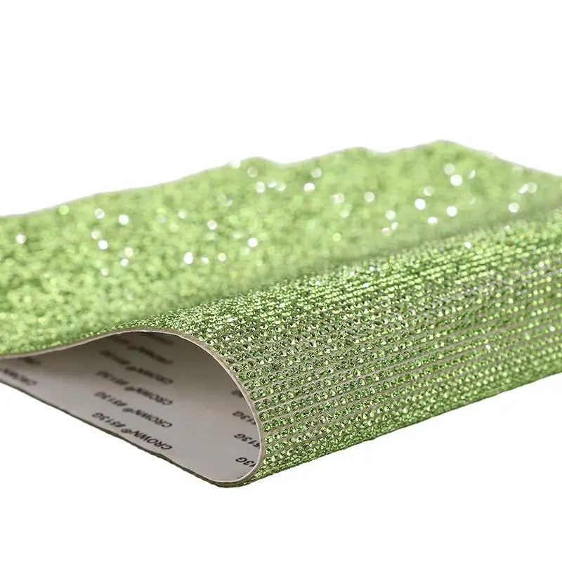 Green sparkling rhinestone adhesive tape rolled up for DIY crafts and decor