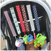 A set of four soft pacifier clips with double-sided prints are hanging inside a baby carrier.