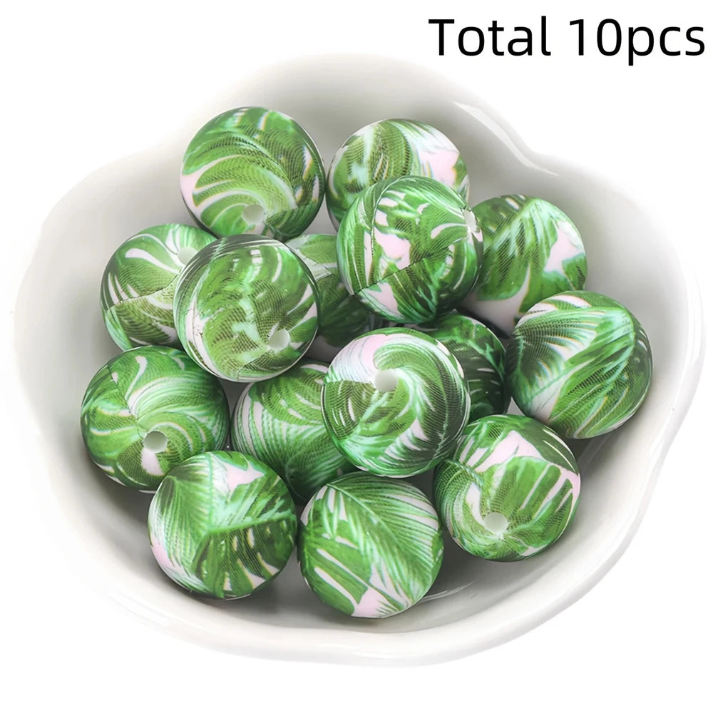 A collection of ten green and pink marbled silicone beads for DIY jewelry making