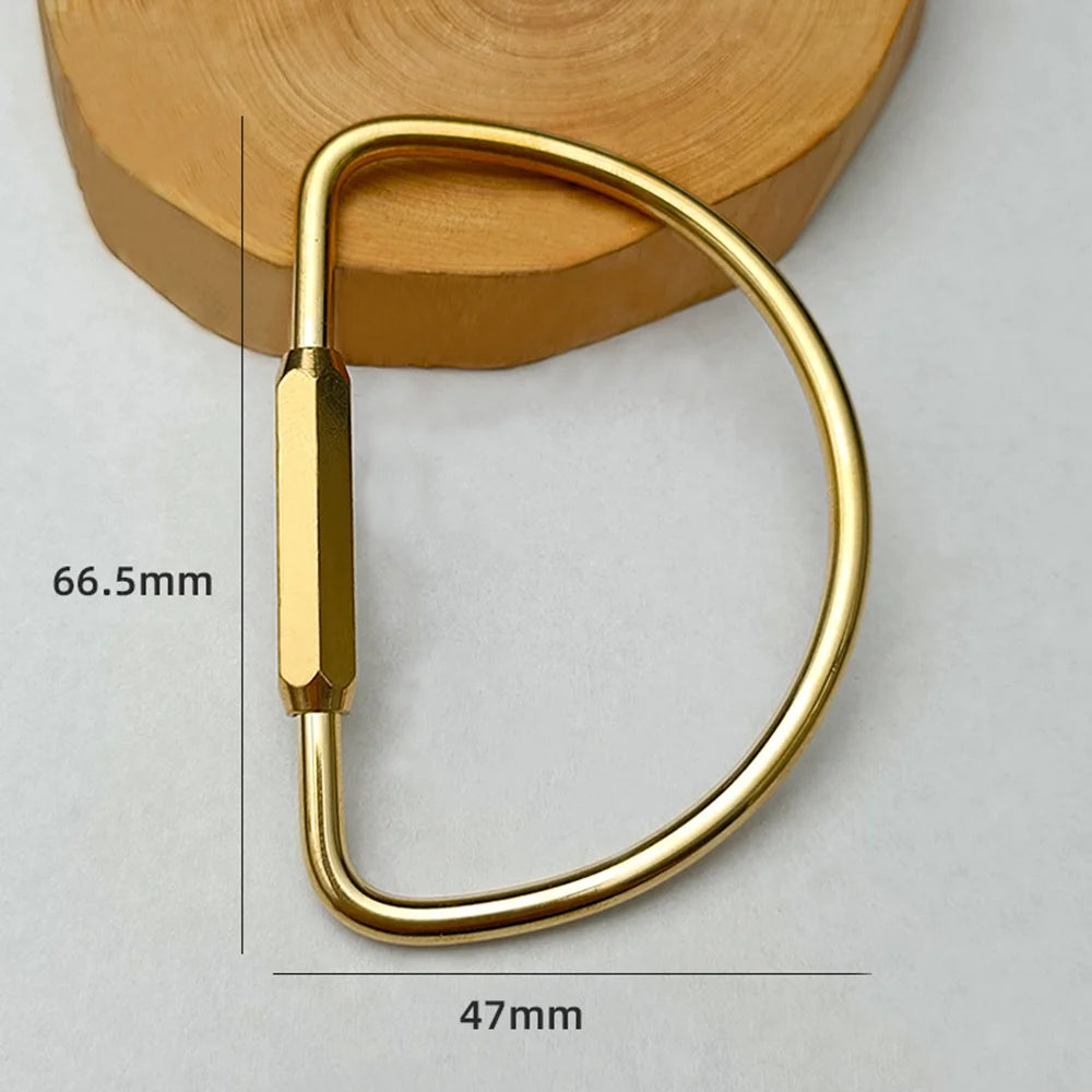 A brass keychain with a locking carabiner clip shown against a light background.