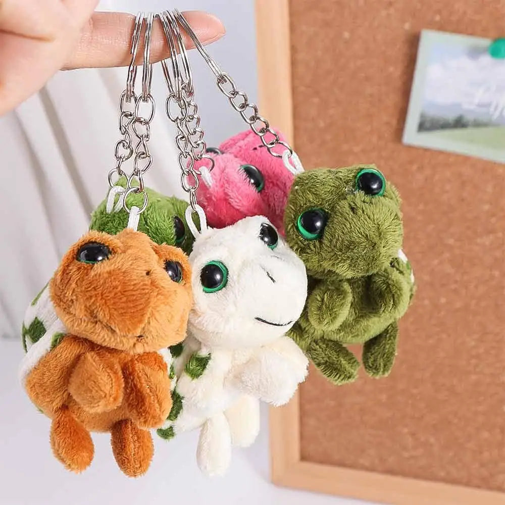 A set of adorable turtle plush keyrings with colorful charms hanging from chains.