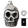 A ceramic Aztec skull whistle with intricate details and a black fabric pouch.