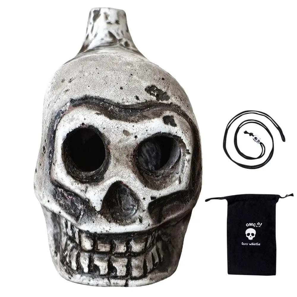 A ceramic Aztec skull whistle with intricate details and a black fabric pouch.