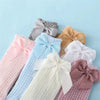 A collection of baby girl lace knee socks with bows in various pastel colors including pink, blue, lavender, and beige.
