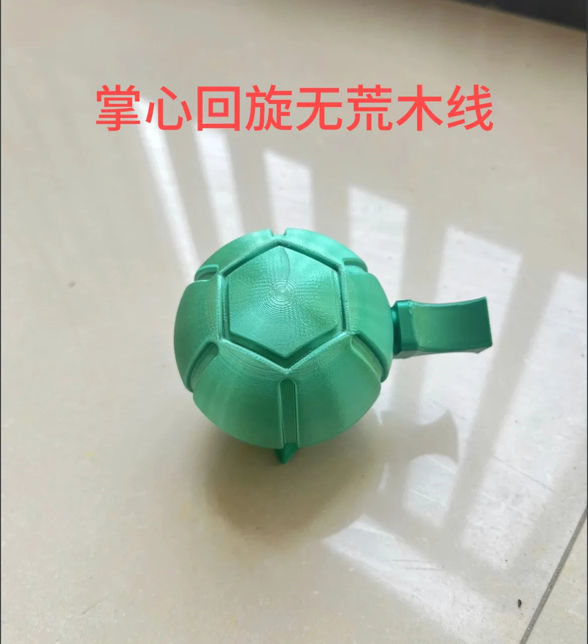 A teal, textured steel ball fidget toy used for stress relief.
