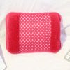 A bright red fuzzy hot water bottle with a pink soft cover resting on a white surface.
