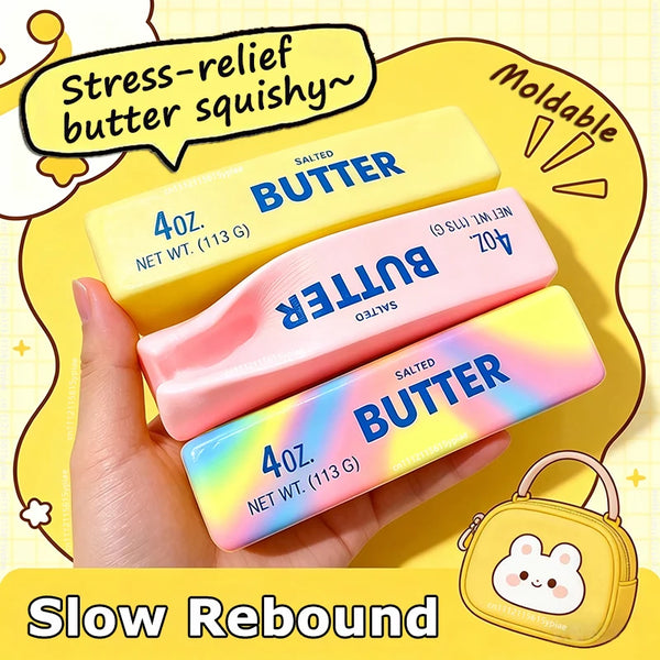 A hand holds a pink butter squeeze toy and a yellow butter squeeze toy against a yellow background.