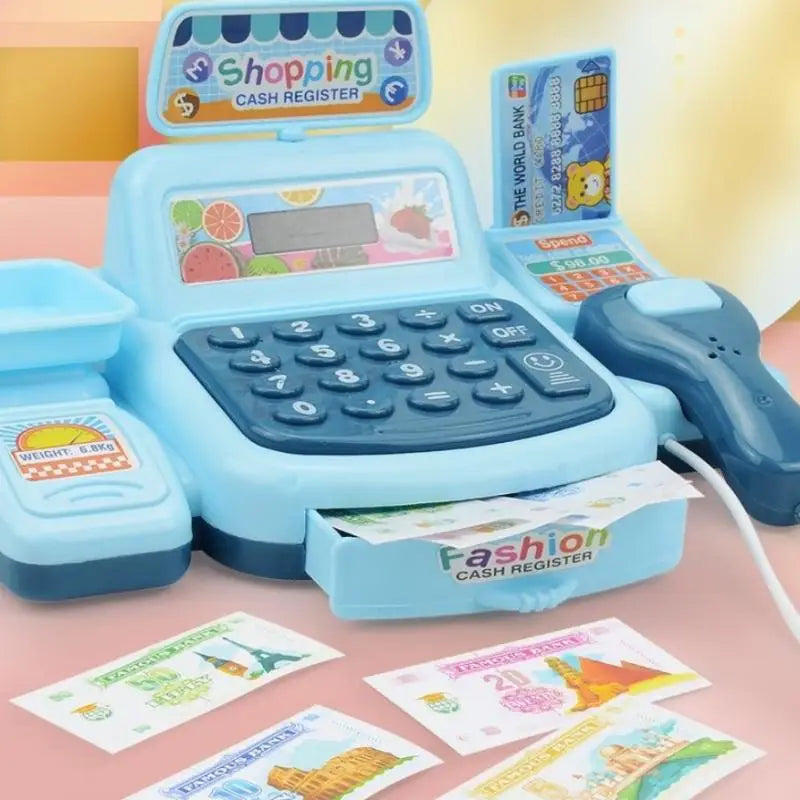 A blue interactive cash register toy with a cash register box and various paper money is displayed on a pink surface.