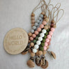 A set of wooden bead pacifier clips with silicone teethers on natural twine.