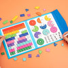 Un livre de fractions en bois bleu ouvert, montrant diverses pièces et graphiques colorés pour l'apprentissage mathématique p