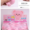A pink squishy pig stress relief toy is shown being held by a hand, along with packaged squishies.