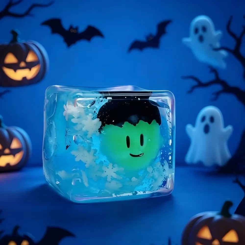A translucent blue ice cube shaped like a ghost is displayed against a dark background with bats and pumpkins.