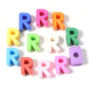 A collection of colorful acrylic letter beads arranged in a circle.