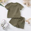 A set of olive green knitted outfit for a baby, including a short-sleeved shirt and matching shorts.