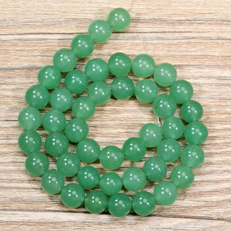 A strand of round, translucent green aventurine gemstone beads for jewelry making
