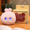 A pink plush rabbit pendant is displayed next to its cardboard packaging.