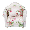 A white mini sofa and pillow set with a floral print for a dollhouse.