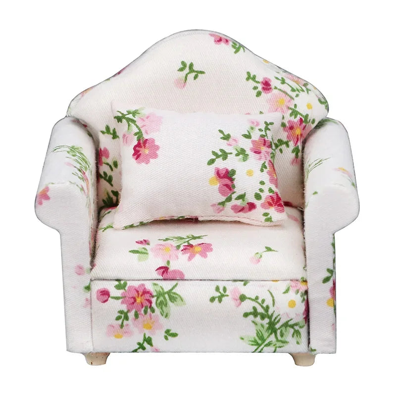 A white mini sofa and pillow set with a floral print for a dollhouse.