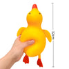 A hand is holding a bright yellow squishy duck stress ball with an orange beak and feet.