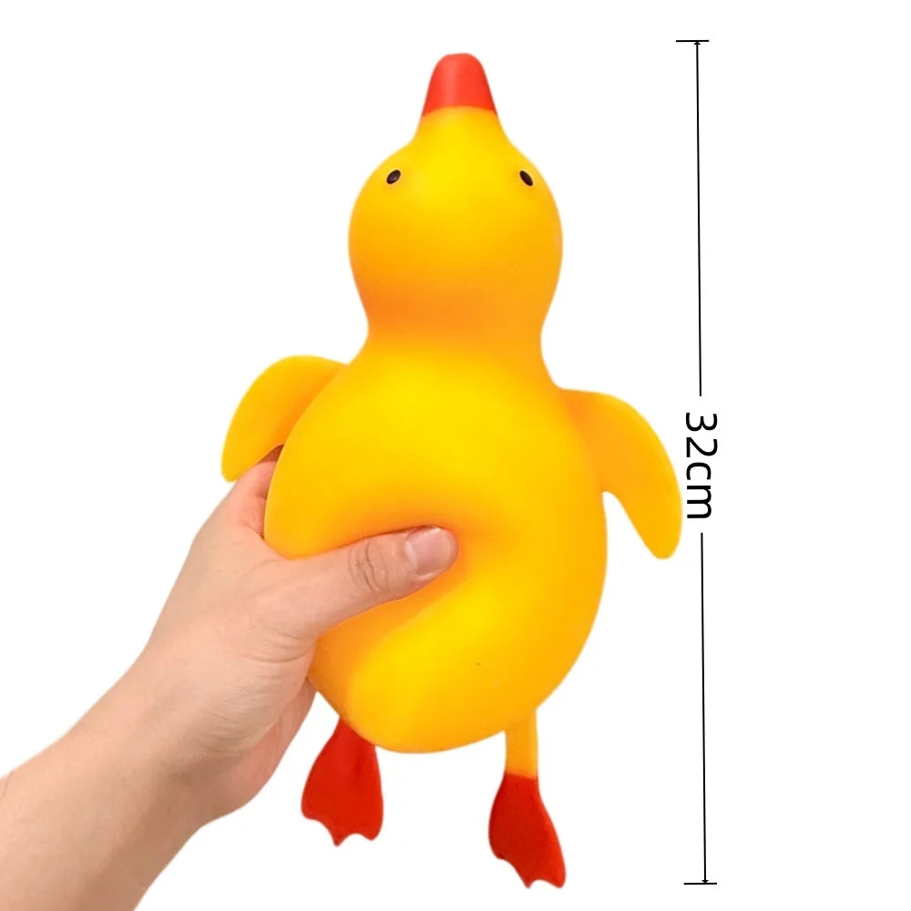 A hand is holding a bright yellow squishy duck stress ball with an orange beak and feet.