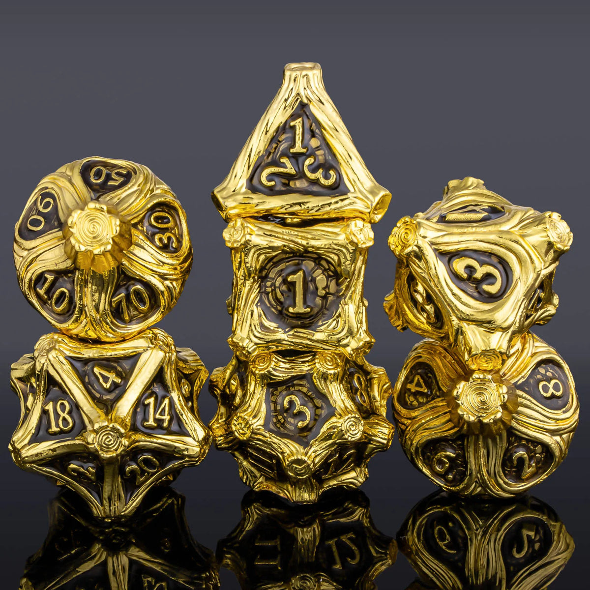 A set of seven gold-colored metal dice, including a skull and dragon design, displayed on a dark surface.