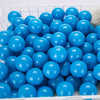 A white basket filled with a large quantity of bright blue plastic play balls.